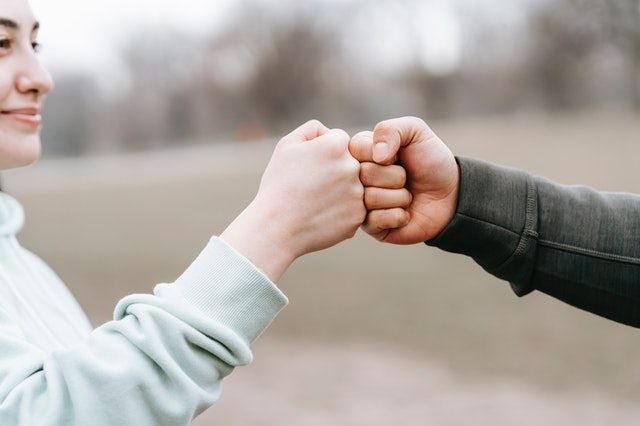 two people fist-bumping
